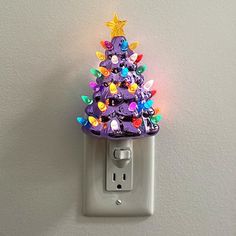 a purple christmas tree light switch cover on a white wall