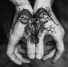 two hands holding each other with tattoos on their palms and one has a bird in the middle