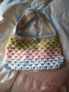 a crocheted purse sitting on top of a bed