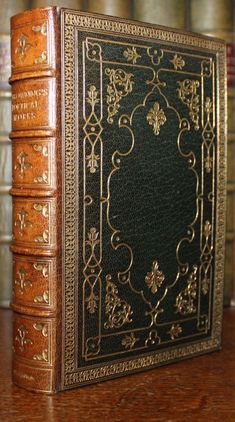 an old book sitting on top of a wooden table in front of bookshelves