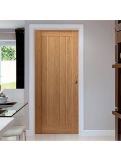 a wooden door in a kitchen next to a table