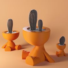 three small cactus plants in yellow pots on top of each other, with one plant growing out of the pot