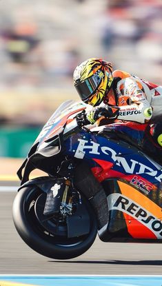 a man riding on the back of a motorcycle down a race track