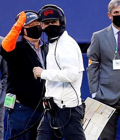 a man wearing a face mask walks with another man