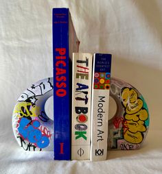 two books are stacked on top of each other in front of a white background with graffiti