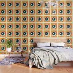 a bedroom with a bed, chandelier and wallpaper that has circles on it