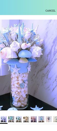 a vase filled with shells and flowers on top of a table