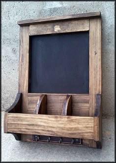 an old wooden chalkboard with three hooks