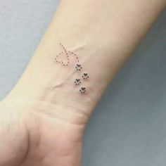 a small tattoo on the wrist of a woman's hand with four little hearts