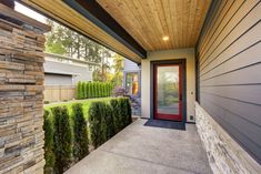 the front entrance to a modern home with red door