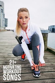 a woman squatting on a dock with headphones in her ears and running shoes