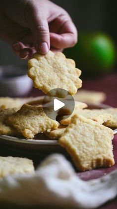 someone is picking up crackers from a plate