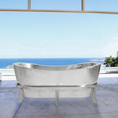 a bathtub sitting on top of a tiled floor next to a large glass window