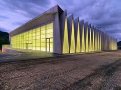 a large building that is lit up with yellow lights on the outside and inside it