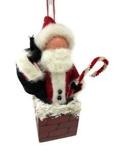 a santa clause ornament hanging from a string