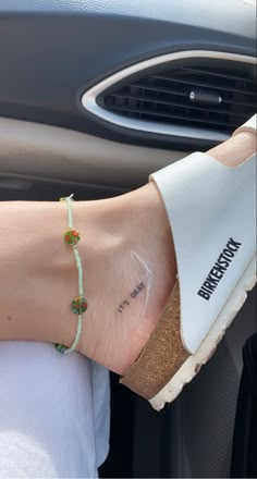 a woman's hand with a bracelet on her wrist in the passenger seat of a car