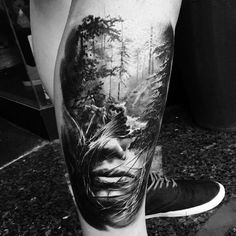 a man's leg with an image of trees on it and his face in the middle