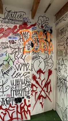 graffiti is on the wall in an empty room with green flooring and walls painted white