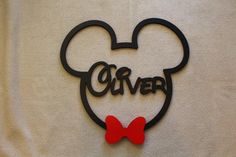 a mickey mouse head with a red bow tie on it's head and the word disney written in black