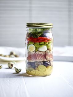 a mason jar filled with pickles, cucumbers and other vegetables