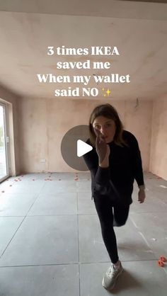 a woman is standing in an empty room with words on the wall above her head