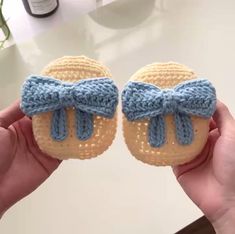 two crocheted baby shoes with bows are shown in front of a counter top