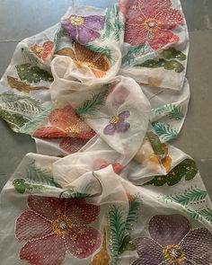 several different colored flowers on white fabric