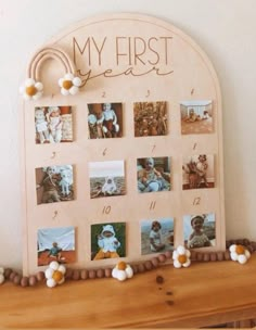 a wooden frame with pictures on it that says, my first year and is decorated with pom poms