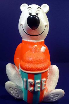 an orange and blue ice cream cup sitting on top of a white bear