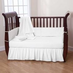 a baby crib with a blanket on top of it and sheets in the middle