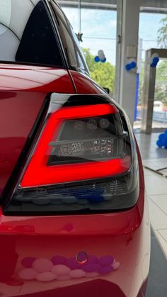 the tail lights of a red car in a showroom