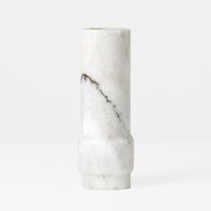 a white marble vase sitting on top of a table