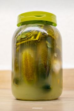 pickles in a glass jar sitting on a table