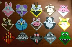 many different types of paper animals on a wooden surface