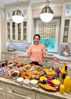 a woman standing in front of a kitchen counter filled with lots of food and drinks