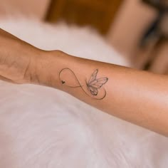 a woman's arm with a butterfly tattoo on the left side of her arm