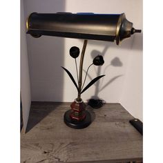 a lamp that is sitting on top of a wooden table in front of a white wall