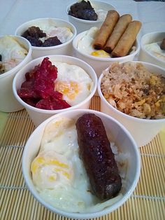 four bowls filled with different types of food on top of a bamboo place mat,