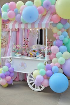 an ice cream cart decorated with balloons and streamers for a birthday party or baby shower