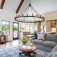 a living room filled with furniture and a large chandelier hanging from the ceiling