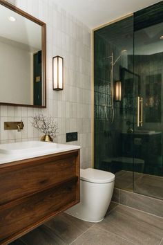 a bathroom with a toilet, sink and shower stall in the middle of the room