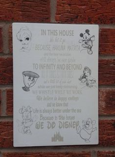 a sign on the side of a brick wall that says in this house we are at disney