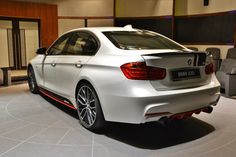 a white car is parked in a showroom