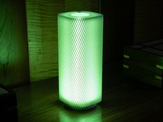 a green lamp sitting on top of a wooden table