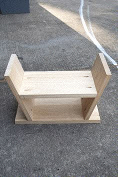 a wooden bench sitting on top of a cement ground