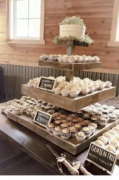 three tiered trays filled with cupcakes on top of a wooden table