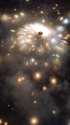 fireworks are lit up in the night sky with bright lights on them and small bubbles floating around