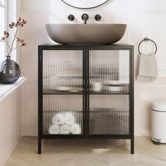 a bathroom with a sink, mirror and towel rack on the wall next to it