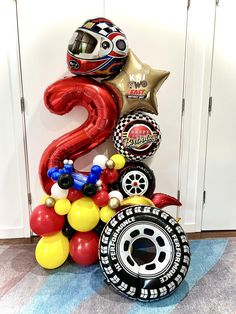 balloons and heliums are arranged in the shape of a number, with a motorcycle helmet on top