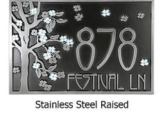 a metal sign that says stainless steel raised with flowers and trees in the background,